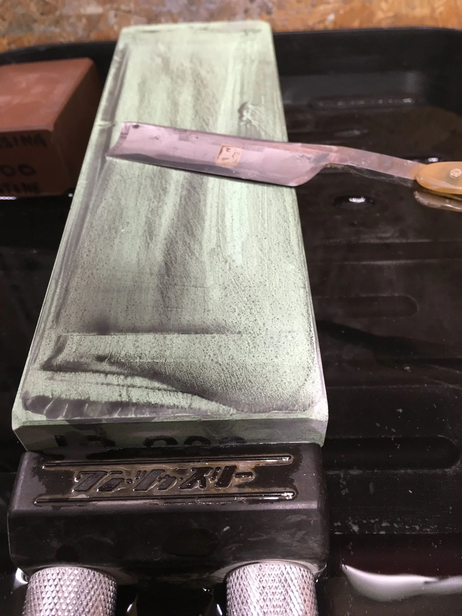 Rasiermesser auf japanischem Wasserstein beim Schärfen